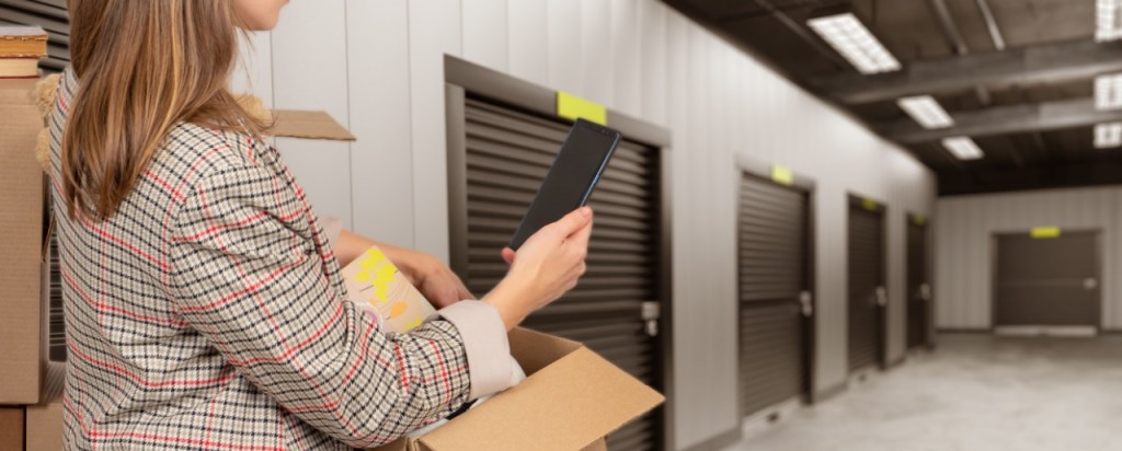 Woman-with-box-in-a-storage-facility.-Saving-money-on-storage-units