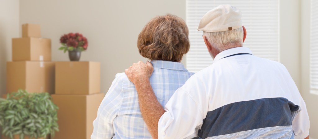 Senior couple with moving boxes in room
