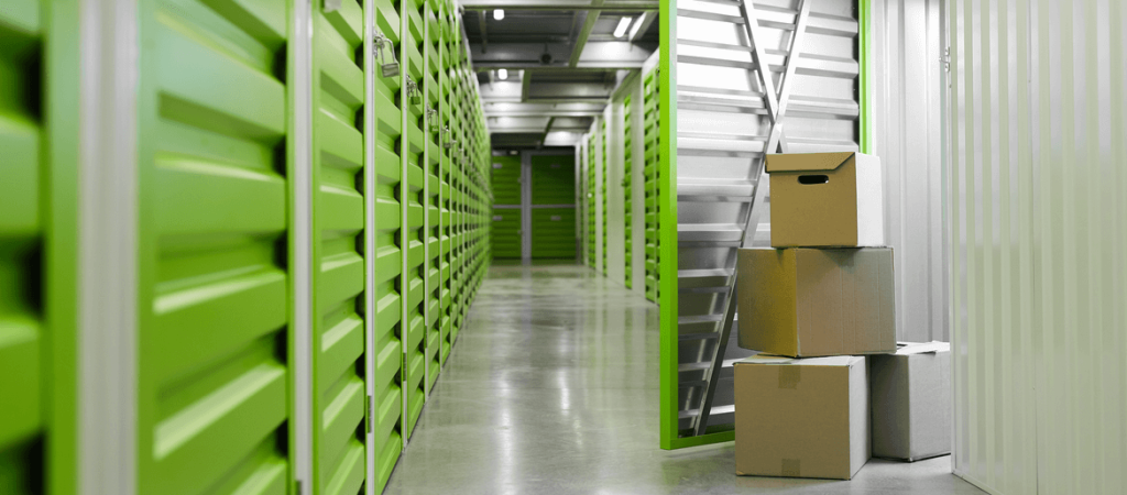 self storage facility with green doors and cardboard boxes
