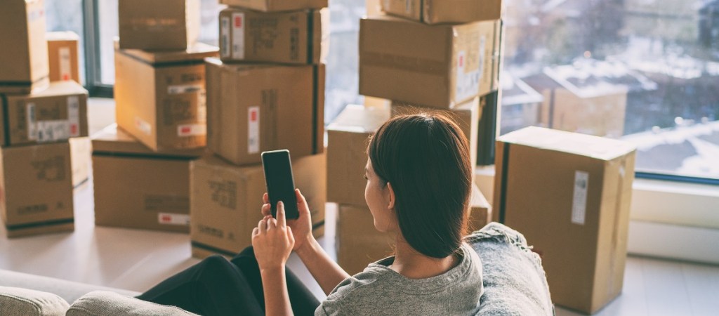 Moving boxes with woman using phone