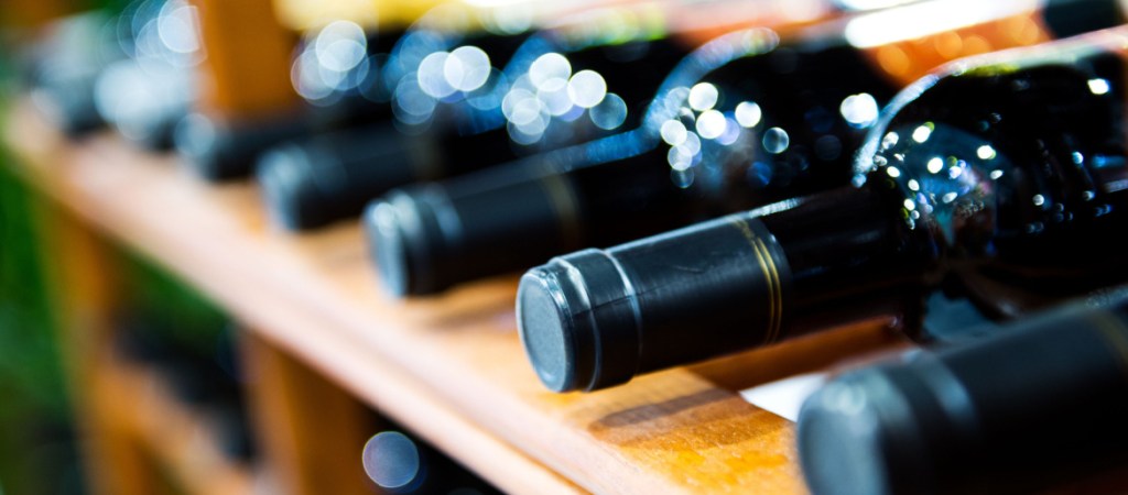 red wine bottles stacked on wooden racks