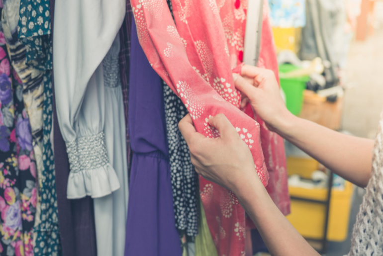 woman going through thrift store clothes