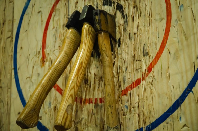 throwing axes stuck in wood wall with target