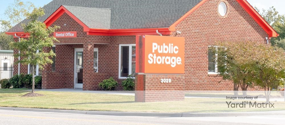 public storage facility brick house with orange sign in front