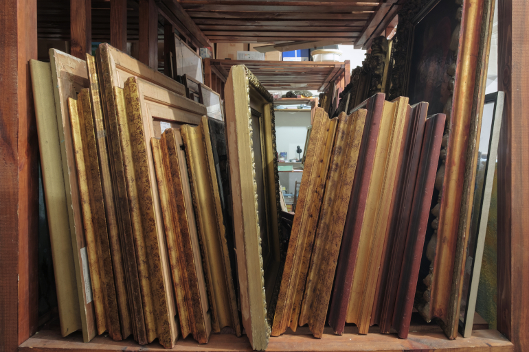 framed paintings stored on shelf