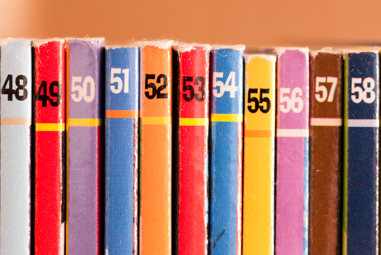 colorful comic books in a row with numbers on spines