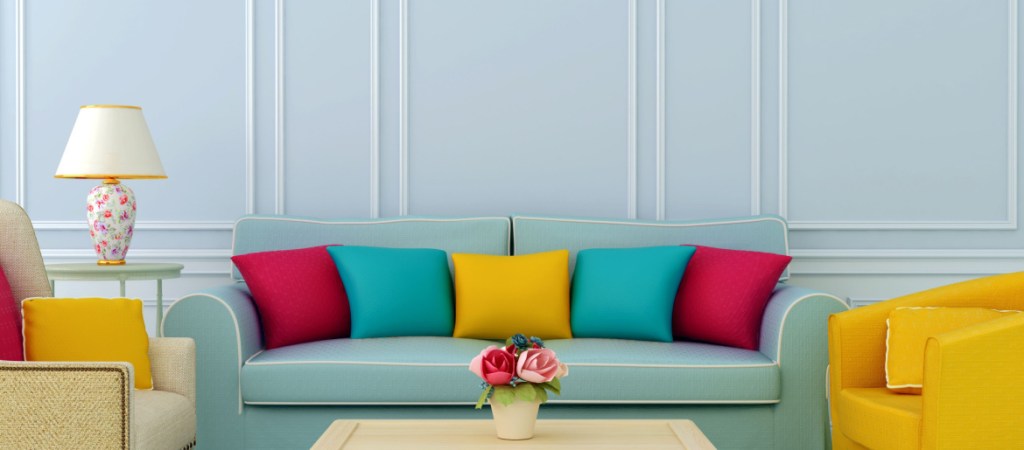 beautiful home with blue sofa and bright chairs with colorful pillows