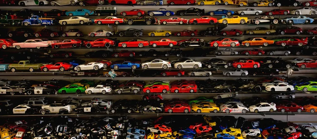 Collection of die-cast model cars displayed on shelves (courtesy of Karen Vardazaryan and Unsplash)