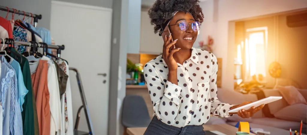 Woman sitting at desk and making a phone call. Businesswoman working from home office and using cell phone