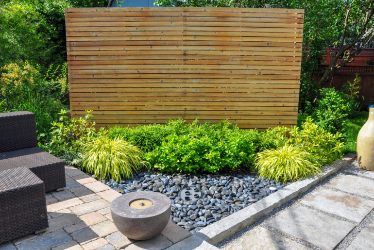 Beach pebbles, square cut flagstone and brick landscape pavers and simple planting