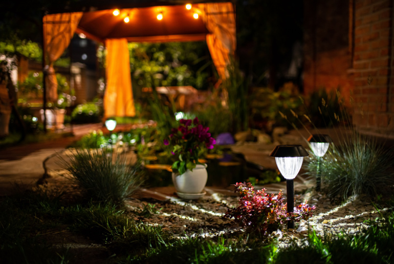 Decorative Small Solar Garden Light, Lanterns In Flower Bed. Garden Design. Solar Powered Lamp