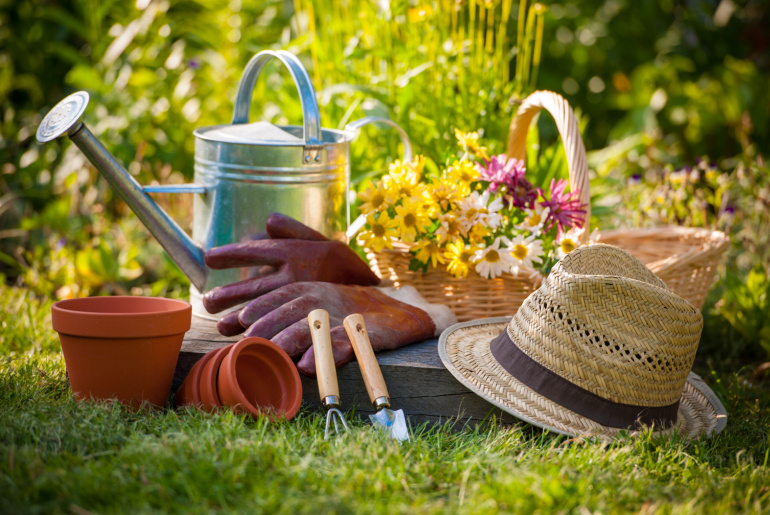 Gardening tools and a straw hat on the grass in the garden (2)