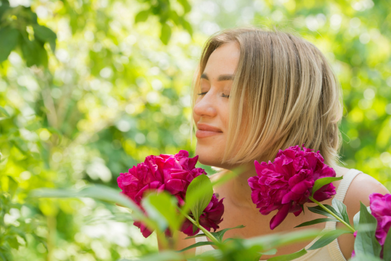 portrait of a young blonde woman with peonies
