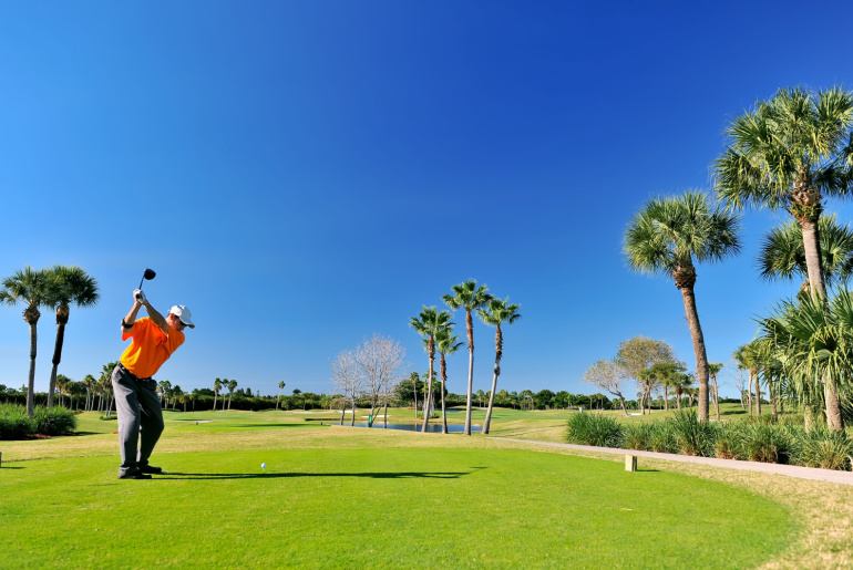 Golfer teeing off on beautiful Florida course