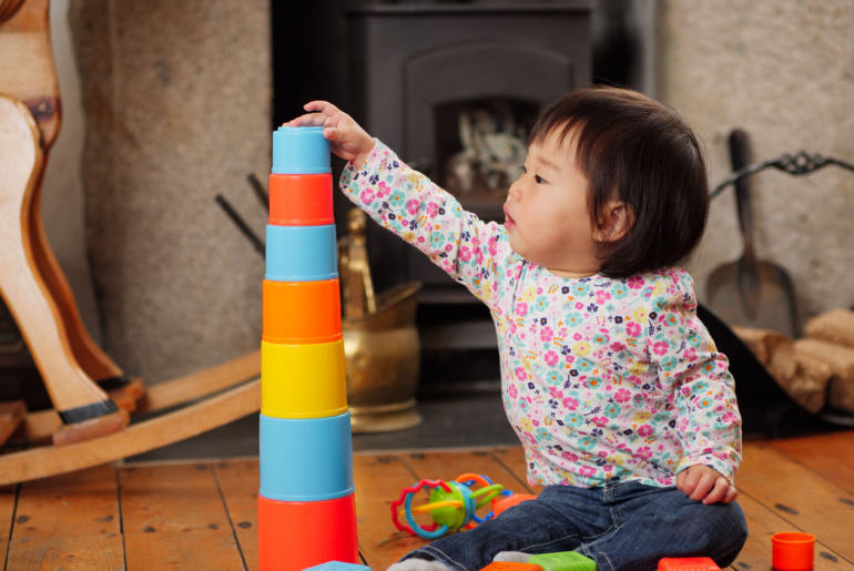baby girl playing stacking cups at home
