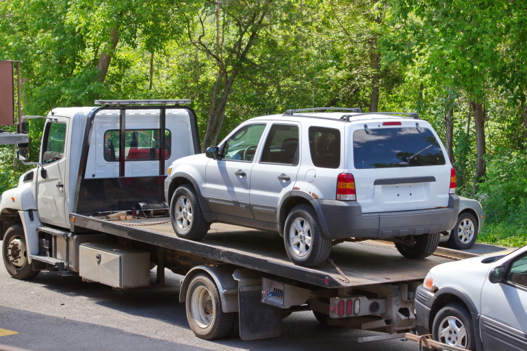 flatbed single vehicle tow truck plus a vehicle towed behind - transport car to another state