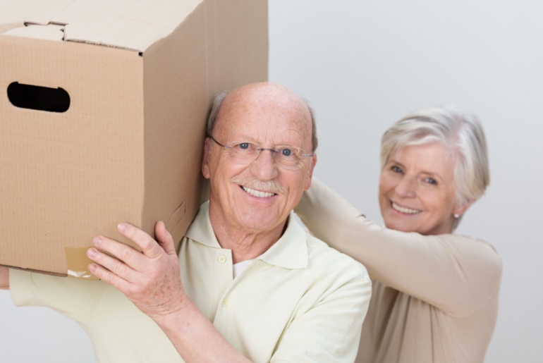 Couple of retirees moving cardboard box