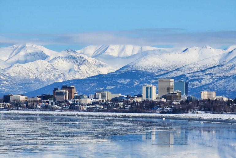 Skyline of Anchorage, Alaska, with snowy mountains in the background