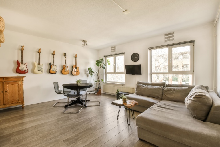 a living room with guitars hanging on the wall