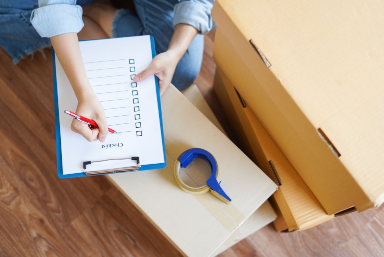 Top-view-of-woman-checking-goods-package-or-packing-before-delivery-or-shipping-to-customers-as-order-in-shopping-online-prepare-relocate-and-move-to-new-house-with-checklist-and-order-list