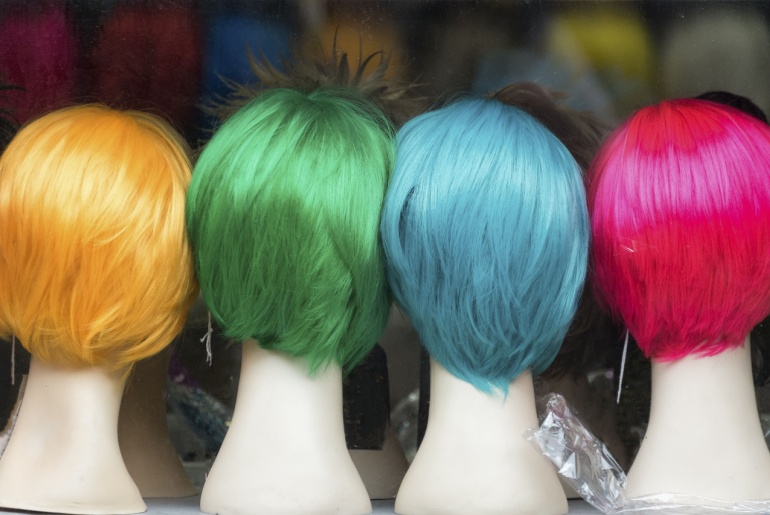 Wig stands with colorful wigs.
