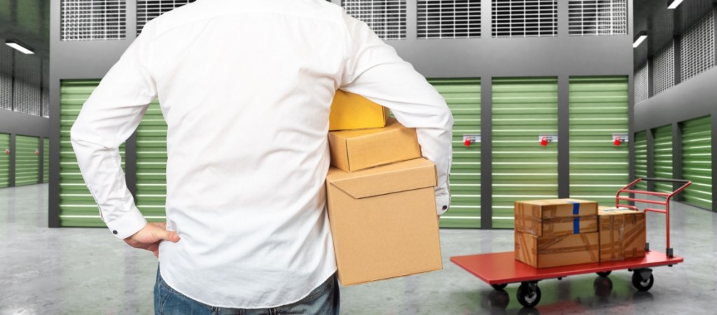 Man with boxes in front of storage unit