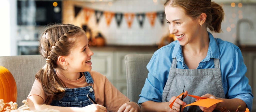 Mother and child crafting Halloween decorations.