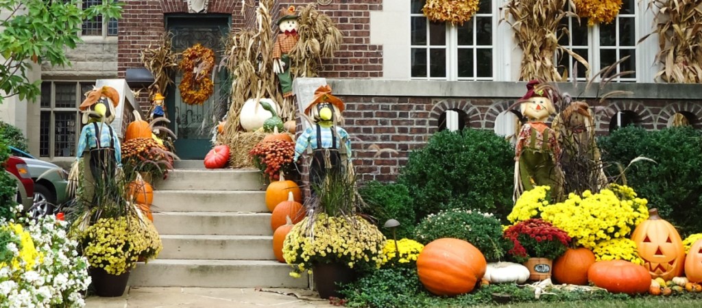 Front porch with Halloween decorations. Brownstone, exposed brick building.