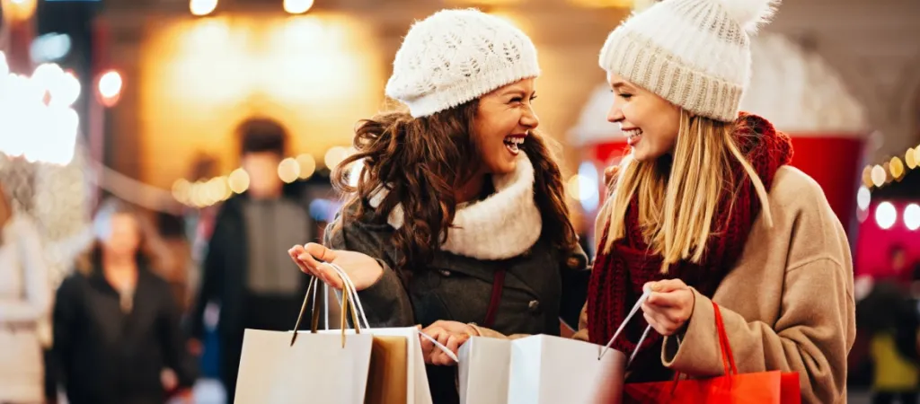 Happy women friends are shopping for presents at Christmas