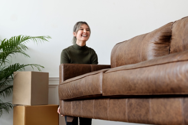 Woman moving leather couch.