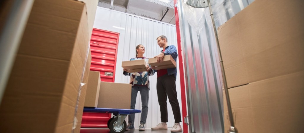 Couple moving boxes into a self storage unit.