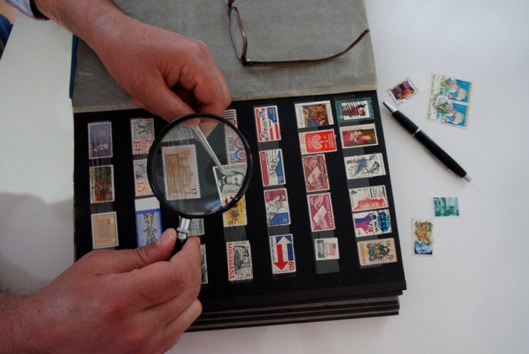 Man looking at stamp collection.
