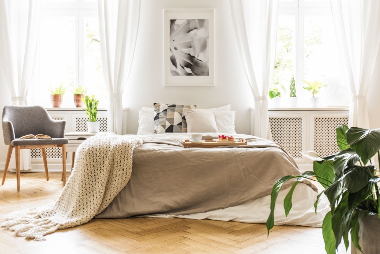 stylish bedroom interior with natural light coming through big windows with sheer curtains