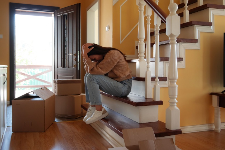 Divorced woman sitting on the stairs of her home