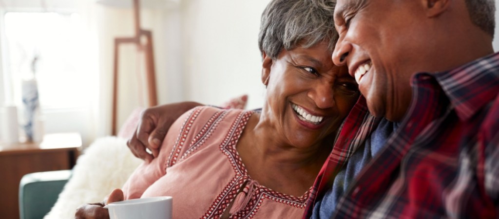 Loving senior couple sitting on sofa at home relaxing.