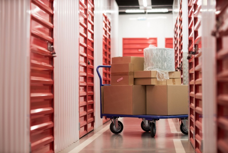 Hand cart with cardboard boxes in self storage facility