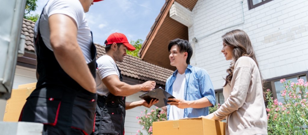 Movers delivering package to couple.