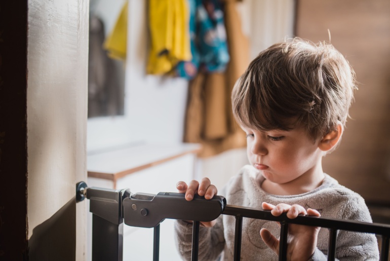 baby near safety gate on stairs