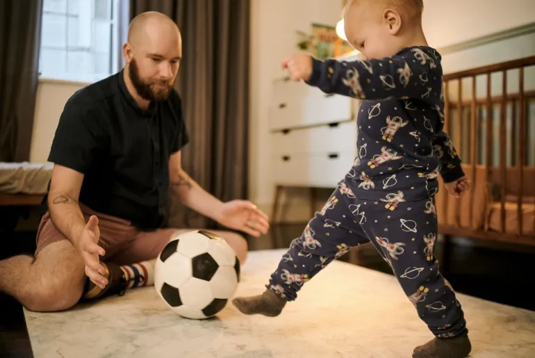 baby and father playing with ball
