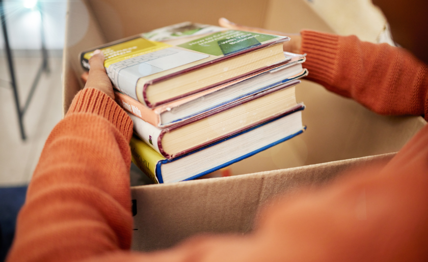 Woman placing used books in cardboard box