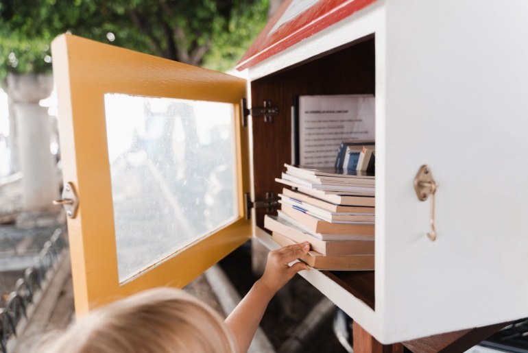 Kid getting a book from the Little Free Library