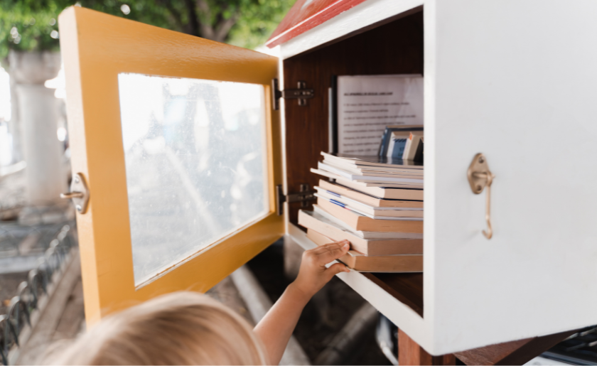 Kid getting a book from the Little Free Library