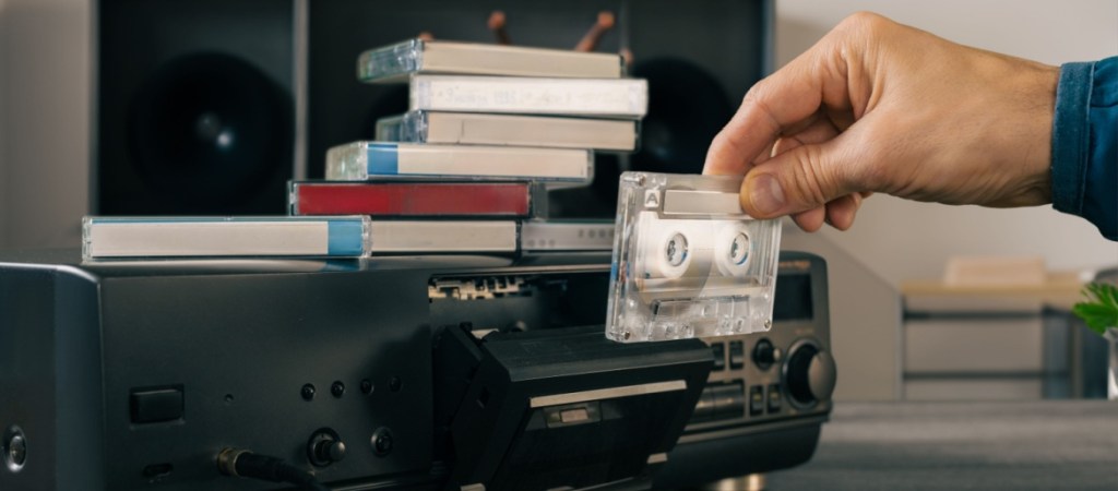Male-hand-loading-audio-tape-cassette-into-vintage-music-player