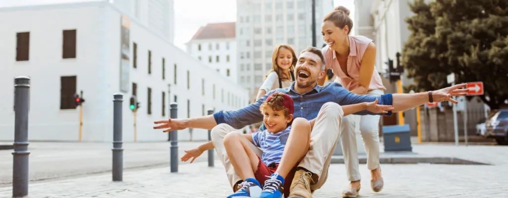 Young family having fun with a skateboard downtown