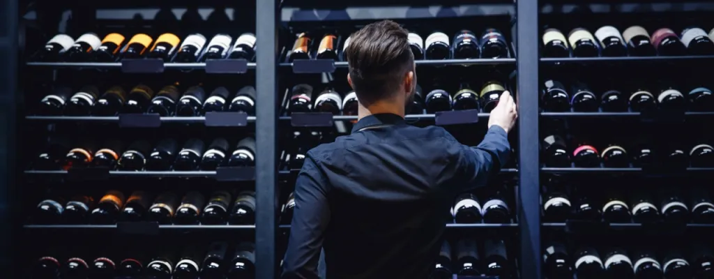 Person in front of wine rack