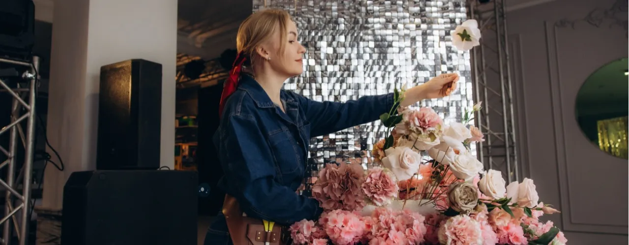 Woman creating a floral arrangement for a special event.