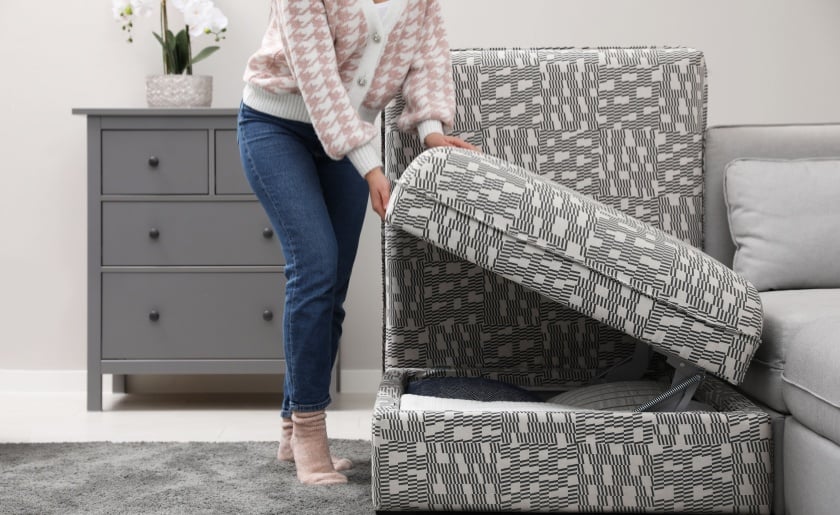 Woman closing modular sofa section with storage in living room.