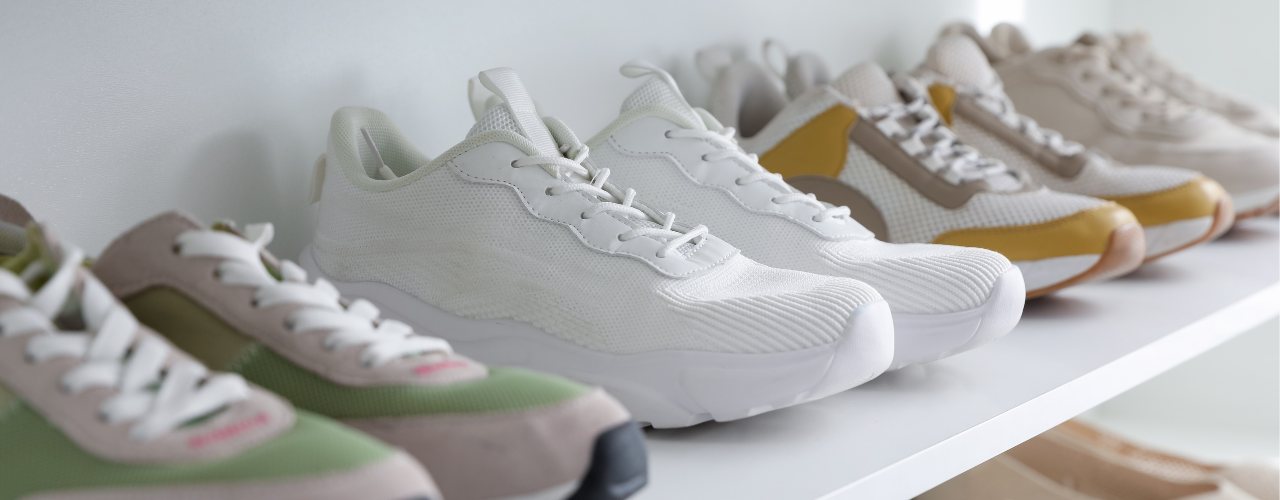 Different sneakers on shelves indoors, closeup.