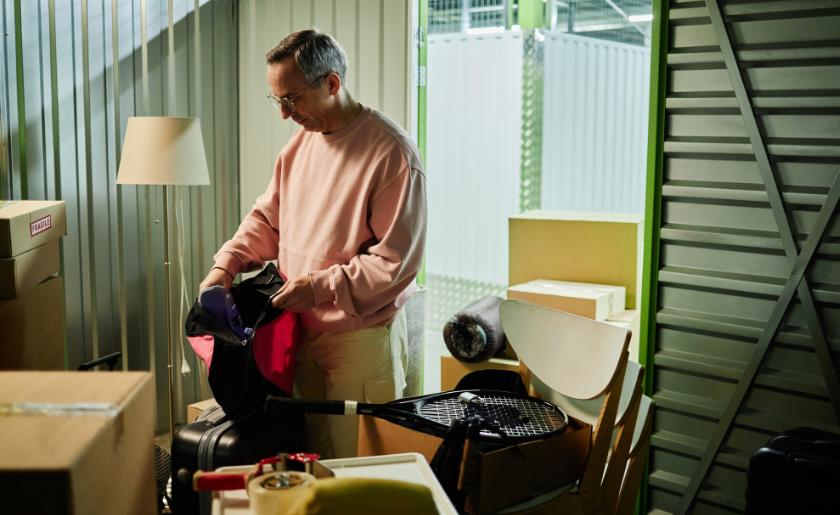 Man sorting belongings in storage unit.
