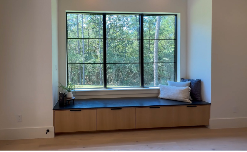 Window seat with cushions and built-in storage in a living room